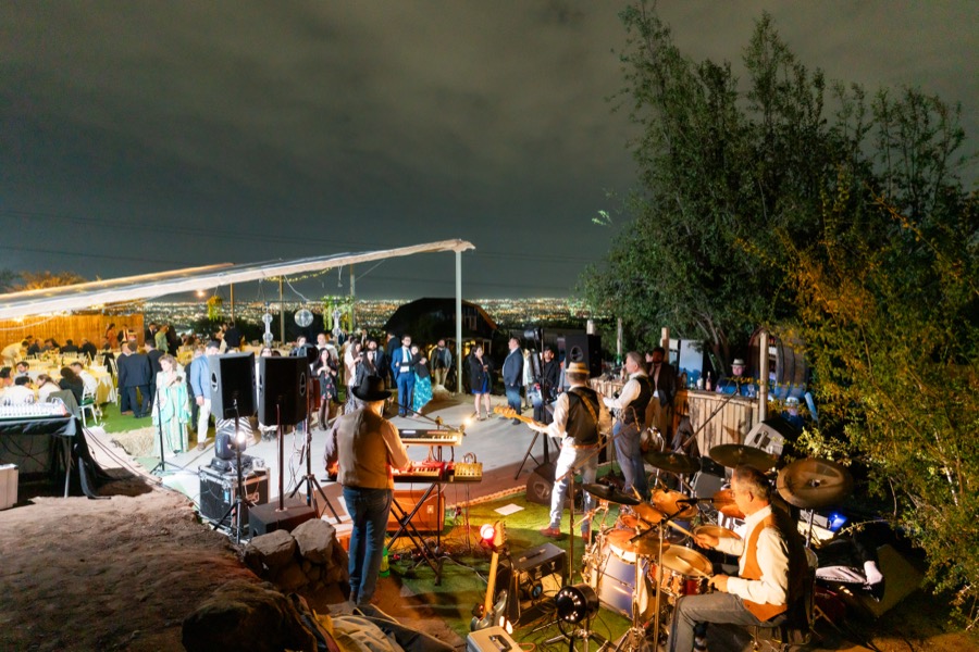 Las mesas iluminadas de noche bajo la carpa, con la fiesta en marcha