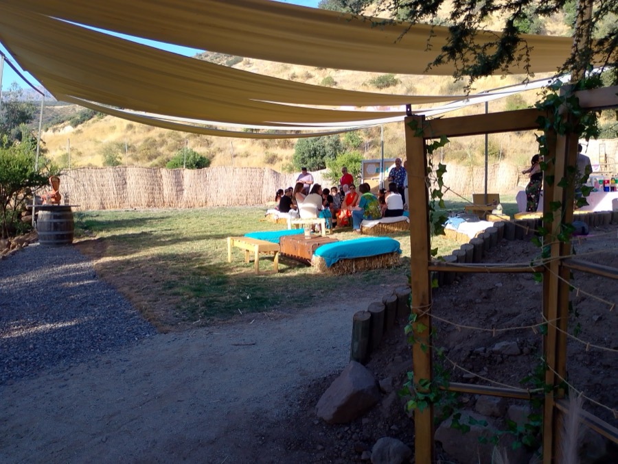 Zona de living al aire libre bajo toldos de tela, con vista al valle