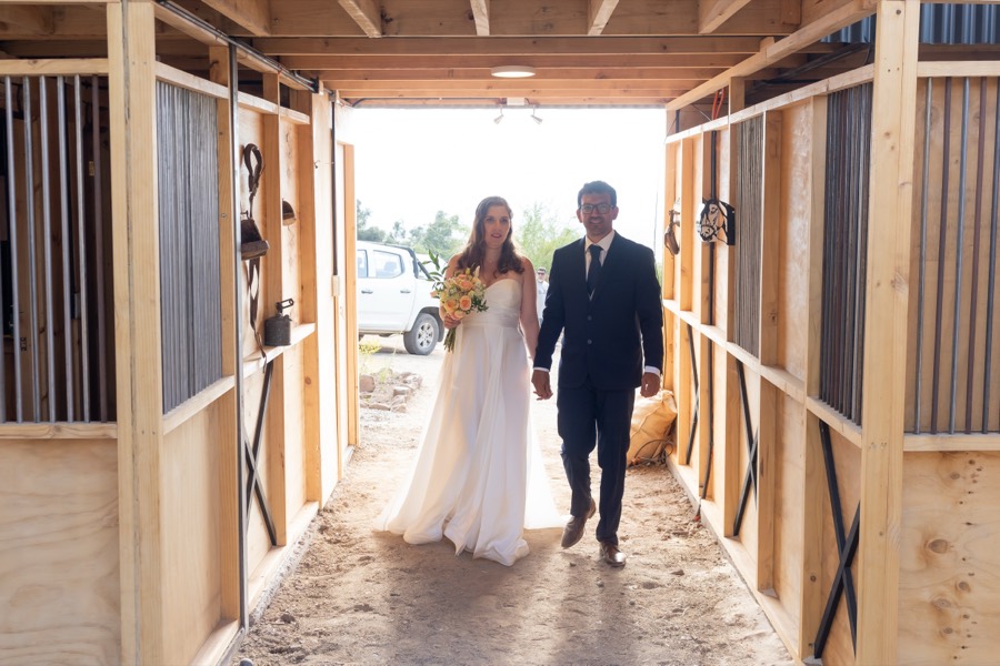 Los novios caminando por un corredor de madera hacia la luz