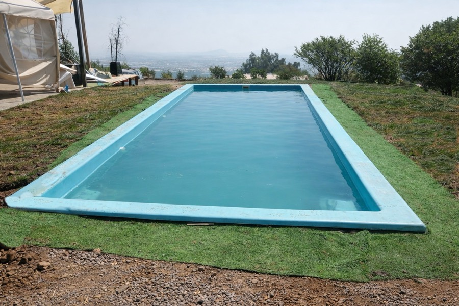 La piscina alargada sobre el pasto en un día despejado