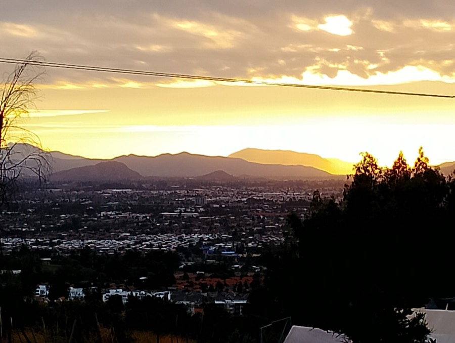 El sol poniéndose sobre Santiago visto desde el cerro